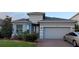 Beautifully landscaped single-Gathering home with a brick-paved driveway and a two-car garage at 17880 Passionflower Cir, Clermont, FL 34714