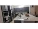 Modern kitchen with stainless steel appliances, ample counter space, and stylish gray cabinetry at 17880 Passionflower Cir, Clermont, FL 34714