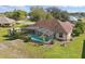 Aerial view of a backyard pool with screen enclosure, shed, mature landscaping, and a fire pit at 1916 Nicholas Pl, St Cloud, FL 34771