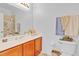 Bathroom featuring a wooden vanity with a marble countertop, a toilet, and neutral-colored walls at 2165 The Oaks Blvd, Kissimmee, FL 34746