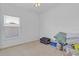 Carpeted bedroom with a window, ceiling fan, and ample space for storage at 2165 The Oaks Blvd, Kissimmee, FL 34746