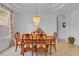 Dining room featuring a chandelier, window, and a wood table with six chairs at 2165 The Oaks Blvd, Kissimmee, FL 34746