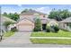 Charming two-story home with a well-manicured lawn and attached two-car garage at 2165 The Oaks Blvd, Kissimmee, FL 34746