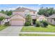 Charming two-story home with a well-manicured lawn and attached two-car garage at 2165 The Oaks Blvd, Kissimmee, FL 34746