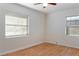 Bright bedroom with wood floors, two windows with blinds, and a ceiling fan at 2320 Amherst Ave, Orlando, FL 32804