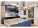 Stylish kitchen featuring an island with granite countertop, modern lighting, and dark wood cabinets at 2320 Amherst Ave, Orlando, FL 32804