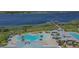 Aerial view of resort-style pool area and community amenities by a scenic lake at 2658 Meadowedge Loop, St Cloud, FL 34772