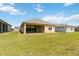 Backyard featuring a covered patio, green grass, and other houses in the community at 2658 Meadowedge Loop, St Cloud, FL 34772