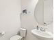 Compact half bath with a modern toilet and a stylish pedestal sink at 2658 Meadowedge Loop, St Cloud, FL 34772