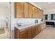 This butler's pantry features light wood cabinets, a white countertop, and stylish decor, perfect for storage and entertaining at 2658 Meadowedge Loop, St Cloud, FL 34772
