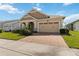 Charming one-story home with a brick paver driveway, two-car garage, and lush green lawn at 2658 Meadowedge Loop, St Cloud, FL 34772