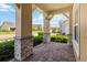 Covered front porch with brick paver flooring and stone-clad support columns, offering a welcoming entry at 2658 Meadowedge Loop, St Cloud, FL 34772