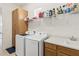 Well-organized laundry room with a sink, counter space, top-of-the-line washer and dryer, and storage cabinets at 2658 Meadowedge Loop, St Cloud, FL 34772