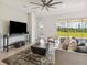 Bright and airy living room with a large TV, modern furniture, and a view of the backyard at 2658 Meadowedge Loop, St Cloud, FL 34772