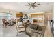 Spacious living area open to the kitchen, featuring a stylish sofa, accent chair, and a modern ceiling fan at 2658 Meadowedge Loop, St Cloud, FL 34772