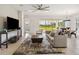 Bright living room boasts a modern ceiling fan, neutral palette, and sliding glass doors to the backyard at 2658 Meadowedge Loop, St Cloud, FL 34772