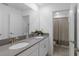 Well-lit bathroom featuring double sinks, grey countertops, and a separate toilet room at 2724 Camden Ln, Davenport, FL 33837