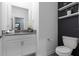Clean bathroom with modern fixtures, floating shelves, and a dark accent wall at 2724 Camden Ln, Davenport, FL 33837