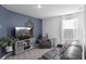 Comfortable living room with large gray sofa, gray entertainment center, and blue accent wall at 2724 Camden Ln, Davenport, FL 33837