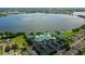 Wide aerial capture highlighting a lakeside community with a clubhouse, pool, tennis courts, and well-maintained streets at 2885 Attwater Loop, Winter Haven, FL 33884