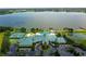 Detailed aerial photograph showcasing a clubhouse with a pool, tennis courts, parking, and a lake in a residential area at 2885 Attwater Loop, Winter Haven, FL 33884