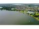 Scenic aerial shot showcasing a community on the water featuring a clubhouse, pool, lake access, and lush greenery at 2885 Attwater Loop, Winter Haven, FL 33884