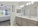 Well-lit bathroom features double sinks, a large mirror, and neutral finishes at 2885 Attwater Loop, Winter Haven, FL 33884