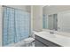 Bright bathroom features a shower-tub combination with tile surround and gray vanity at 2885 Attwater Loop, Winter Haven, FL 33884
