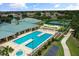 View of an inviting community pool with an expansive deck, poolside seating, and manicured landscaping at 2885 Attwater Loop, Winter Haven, FL 33884