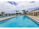 Inviting community pool with clear blue water, comfortable lounge chairs, and scenic lake views in the background at 2885 Attwater Loop, Winter Haven, FL 33884