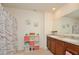 Bright bathroom featuring a double vanity, decorative accents, and a shower with stylish curtain at 297 Gina Ln, Davenport, FL 33837