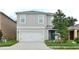 Inviting two-story home with a two-car garage, complemented by a neatly landscaped front yard and a blue front door at 297 Gina Ln, Davenport, FL 33837