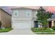 Charming two-story home with a well-manicured lawn and a two-car garage, complete with a decorative front door at 297 Gina Ln, Davenport, FL 33837