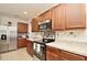 Modern kitchen featuring stainless steel appliances, stone countertops, and wooden cabinets with contemporary hardware at 297 Gina Ln, Davenport, FL 33837