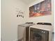 Functional laundry room with modern silver washer and dryer, complemented by New York themed decor at 297 Gina Ln, Davenport, FL 33837