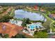 Aerial view of the community pool and clubhouse by a lake, location marked by a red pin at 3055 Yellow Lantana Ln, Kissimmee, FL 34747
