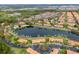 Wide aerial view of a community with lakeside townhomes, a pool, and green spaces at 3055 Yellow Lantana Ln, Kissimmee, FL 34747