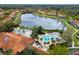 Stunning aerial view of the community pool and clubhouse nestled by a peaceful lake at 3055 Yellow Lantana Ln, Kissimmee, FL 34747