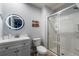 Stylish bathroom featuring a glass shower and a modern vanity with round mirror at 3055 Yellow Lantana Ln, Kissimmee, FL 34747