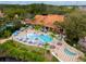 Stunning community pool area with palms, umbrellas, lounge chairs, and adjacent clubhouse at 3055 Yellow Lantana Ln, Kissimmee, FL 34747