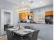 Cozy dining room with a modern chandelier and view into the modern kitchen at 3055 Yellow Lantana Ln, Kissimmee, FL 34747