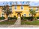 Charming yellow townhome with lush landscaping, sidewalk, and a welcoming entrance at 3055 Yellow Lantana Ln, Kissimmee, FL 34747