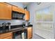 Beautiful kitchen with granite countertops, wood cabinetry, and natural light from the window at 3055 Yellow Lantana Ln, Kissimmee, FL 34747