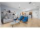 Open-concept living area with bright blue accent chairs and view into the kitchen at 3055 Yellow Lantana Ln, Kissimmee, FL 34747
