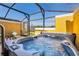 Covered patio with a hot tub, greenery and seating at 3055 Yellow Lantana Ln, Kissimmee, FL 34747