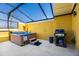 Enclosed patio with a hot tub and grill at 3055 Yellow Lantana Ln, Kissimmee, FL 34747