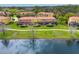 Rear exterior of townhomes facing a serene lake, featuring screened patios and lush lawns at 3055 Yellow Lantana Ln, Kissimmee, FL 34747