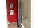 Bathroom showcasing a red wall, framed art, towel rack, and a shower with a gray curtain at 3100 Parkway Blvd # 325, Kissimmee, FL 34747
