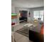 View of a living room with bedroom in the background, neutral tones, and a television at 3100 Parkway Blvd # 325, Kissimmee, FL 34747