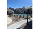 Community pool with lounge chairs, palm trees, and an umbrella in a fenced-in area at 3100 Parkway Blvd # 325, Kissimmee, FL 34747
